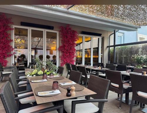 een restaurant met tafels en stoelen en bloemen bij Résidence de la libération in Schifflange
