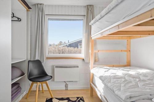 a bedroom with a bunk bed and a chair and a window at 132-Thisted-Sotungevej-31 in Thisted