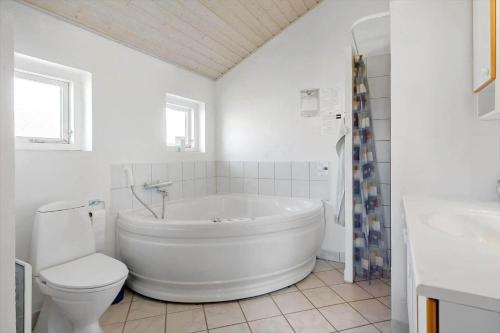 a white bathroom with a tub and a toilet at 546-Thisted-Kuttervej-16 in Thisted