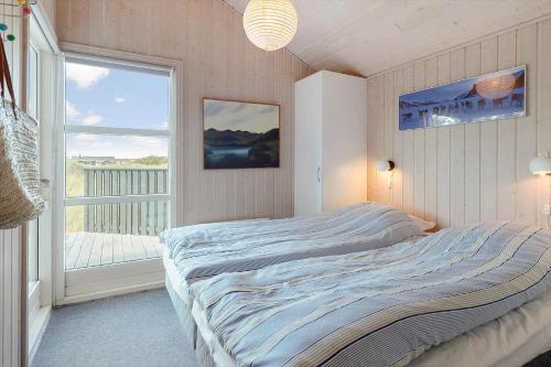 a bedroom with a bed and a large window at 546-Thisted-Kuttervej-16 in Thisted
