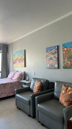 a living room with a couch and a bed at Farol da Barra 209 in Salvador