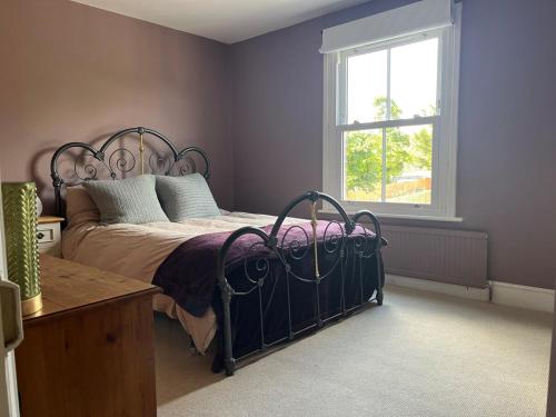 a bedroom with a bed and a window at Edwardian House in Stamford in Ryhall