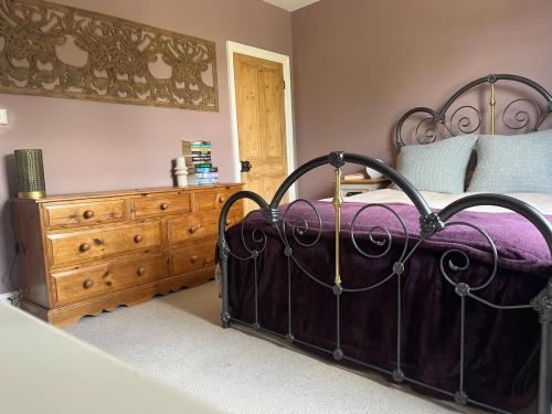 a bedroom with a bed and a wooden dresser at Edwardian House in Stamford in Ryhall
