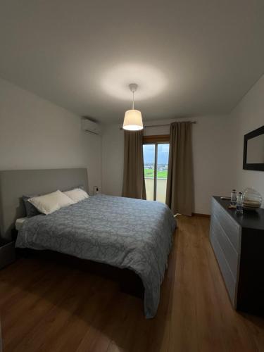 een slaapkamer met een bed en een groot raam bij Alojamento Local Pando in Aveleda