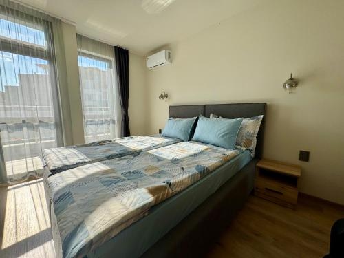 ein Schlafzimmer mit einem großen Bett und blauen Kissen in der Unterkunft The Golden spot Modern Central Apartment with Garage and Balcony, Quiet Location in Yambol