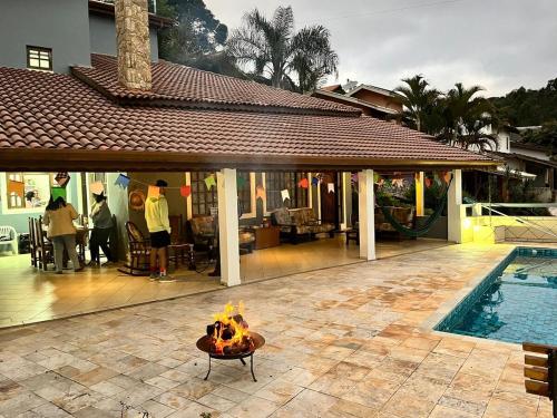 a patio with a fire pit next to a pool at Pôr do Sol - Atibaia in Atibaia