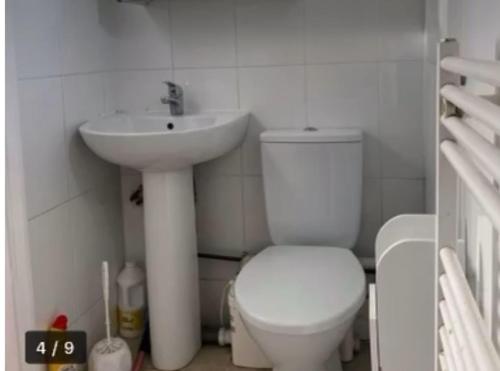 een witte badkamer met een toilet en een wastafel bij Abidjan compact single room private entrance in Feltham