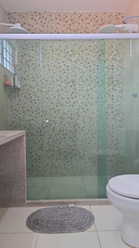 a bathroom with a glass shower with a toilet at Flat aconchegante em Itamaracá in Itamaracá