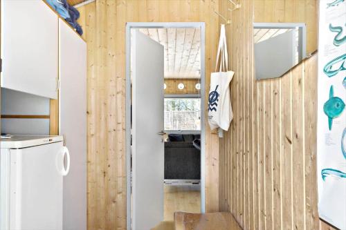 a kitchen with a door leading into a kitchen with wooden walls at 862-Thisted-Nordsovej-162 in Thisted