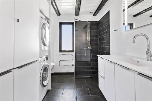 een witte badkamer met een wastafel en een wasmachine bij 142-Thisted-Pighvarvej-4 in Thisted