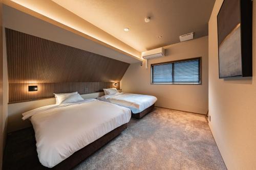 een slaapkamer met twee bedden en een raam bij KOS Restaurant & Hotel in Fujikawaguchiko