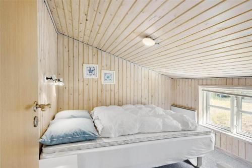a bedroom with a white bed with a wooden ceiling at 710-Thisted-Klitrosevej-10 in Thisted