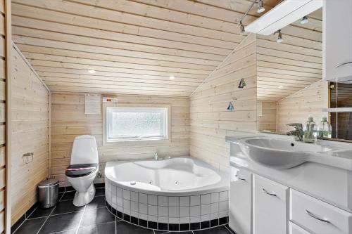 een badkamer met een bad, een wastafel en een toilet bij 980-Thisted-Spanggardsvej-35 in Torsted