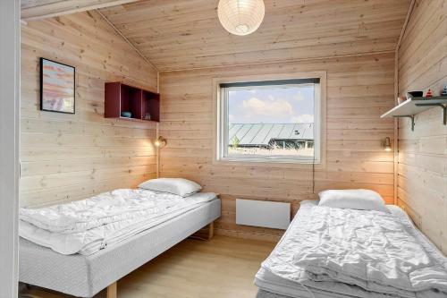 twee bedden in een kamer met houten wanden bij 980-Thisted-Spanggardsvej-35 in Torsted