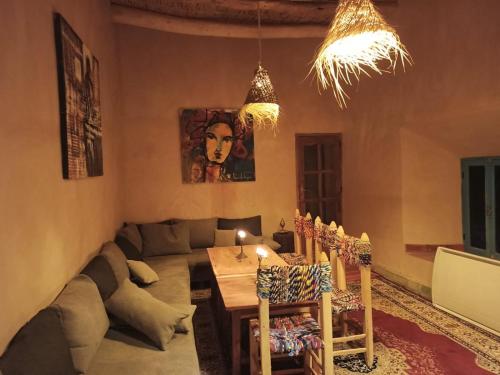 een woonkamer met een bank, een tafel en stoelen bij Trésors des Ancêtres in Ibrahene