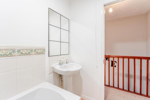 a white bathroom with a sink and a bath tub at Modern Three Bedroom House Free parking wifi in Bristol