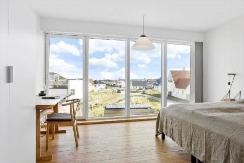 a bedroom with a bed and a desk and windows at 1053-Thisted-Kraenhavs-Sti-8 in Torsted