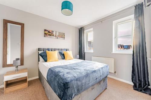 a bedroom with a bed and two windows at Modern Three Bedroom House Free parking wifi in Bristol