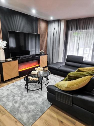 a living room with a black couch and a television at Spacious Home in Vila Nova de Gaia Porto