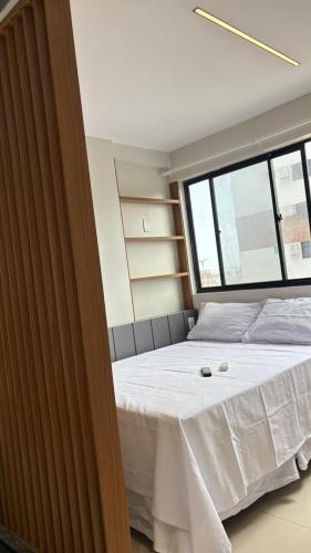 een bed in een kamer met een groot raam bij Studio moderno Alu lounge 103 in São Luís