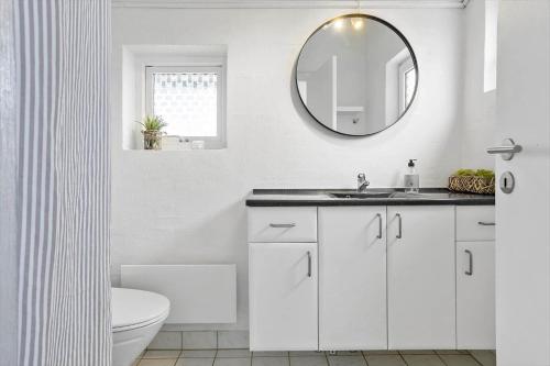 ein weißes Badezimmer mit Waschbecken und Spiegel in der Unterkunft 760 Thisted - Pighvarvej 30 in Thisted