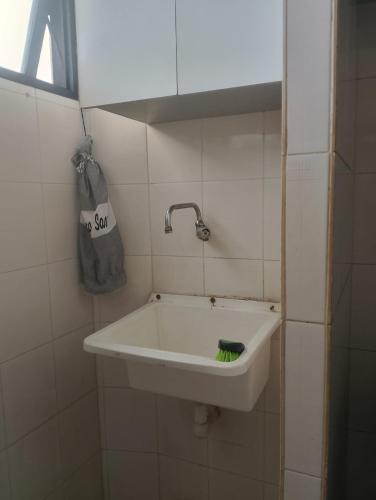 a bathroom with a sink with a green brush at Apartamento BEIRA MAR - Edifício Mar Del Plata in Itamaracá