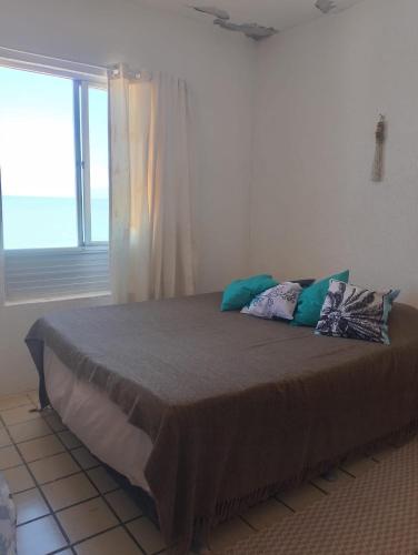 a large bed in a room with a window at Apartamento BEIRA MAR - Edifício Mar Del Plata in Itamaracá
