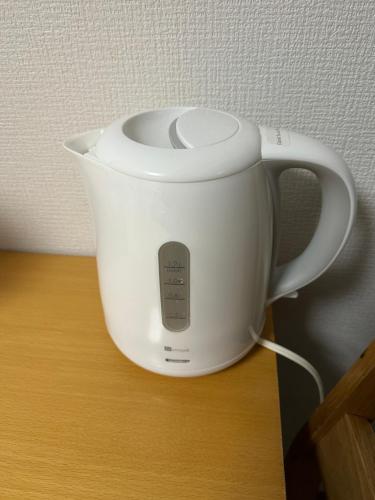 a white slow cooker sitting on top of a table at Guest House" Ro" takezaki in Shimonoseki