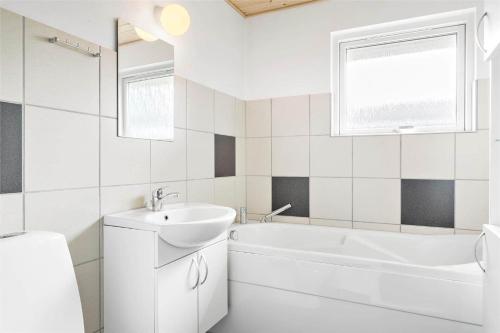 een witte badkamer met een wastafel en een bad bij 695-Thisted-Fiskervej-80 in Thisted