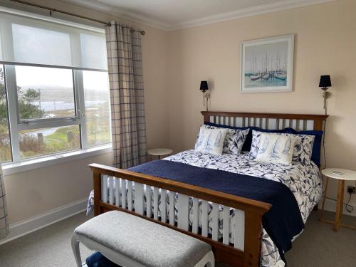 ein Schlafzimmer mit einem Bett und einem Stuhl und Fenstern in der Unterkunft Tigh-na-Greine in Carloway