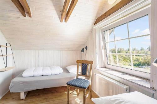 a bedroom with a bed and a chair and a window at 204-Vestervig-Lodbjergvej-4 in Vestervig