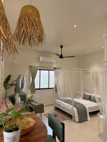 een slaapkamer met een hemelbed en een eetkamer bij AT Alibaug - A Boho Boutique Stay in Alibaug