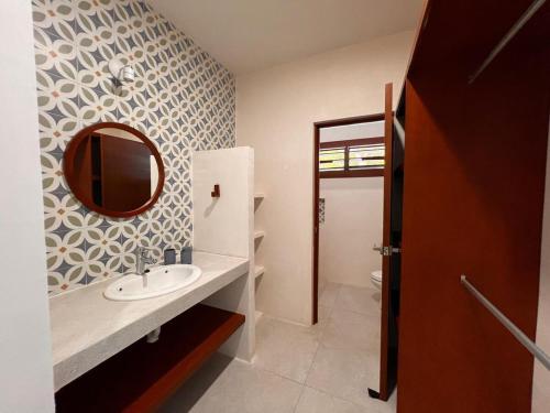 ein Badezimmer mit Waschbecken und Spiegel an der Wand in der Unterkunft Beach house Chuchos in Chelem