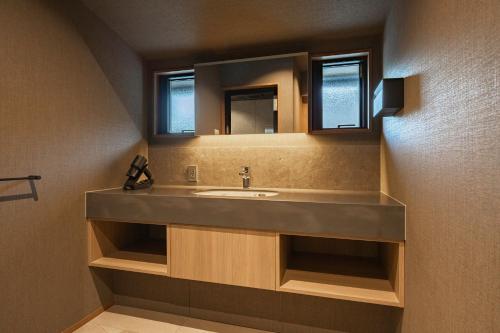 een badkamer met een wastafel en een spiegel bij KOS Restaurant & Hotel in Fujikawaguchiko