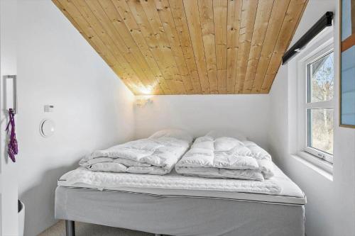 a bed in a room with a wooden ceiling at 1309-Thisted-Blabaervej-2 in Thisted