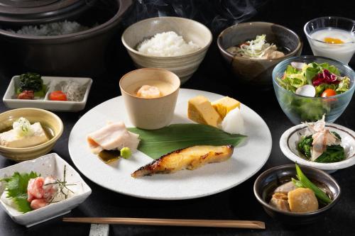 a table topped with plates of food and bowls at KOS Restaurant & Hotel in Fujikawaguchiko