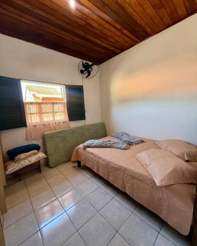a bedroom with a bed and a chair in it at Casa completa Av Roberto da Silveira in Paraty