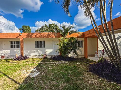 a house with palm trees in front of it at Sol y Luna Hospedaje in Valladolid
