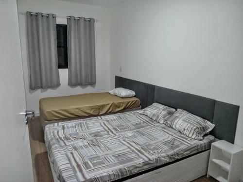 une chambre avec deux lits et une fenêtre dans l'établissement Casa das Cachoeiras, à Botucatu