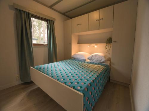 una camera da letto con un letto con un piumone blu di Stay with Beach and Minigolf Views a Overbroek