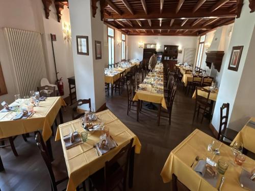 un restaurant avec des tables et des chaises dans une salle dans l'établissement Studio apartment with air conditioning, à Ceresole Reale