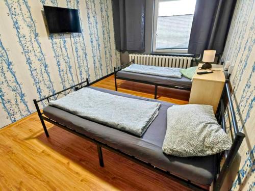 twee bedden in een kleine kamer met een tv bij Family-Friendly Guesthouse in the Oderbruch in Genschmar