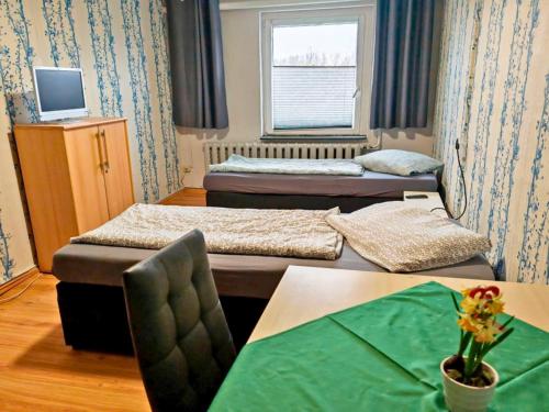 ein Zimmer mit zwei Betten und einem Tisch und einem Fenster in der Unterkunft Cosy apartment in the Oderbruch in Genschmar