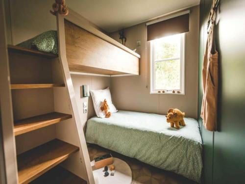 a small room with a bunk bed and a window at 6-Guest Escape with Private Garden & Wi-Fi in Overbroek