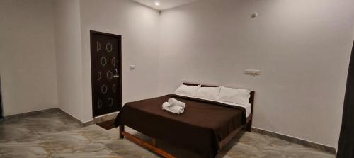 een slaapkamer met een bed met twee handdoeken erop bij La Nature Retreat in Kuilapayam