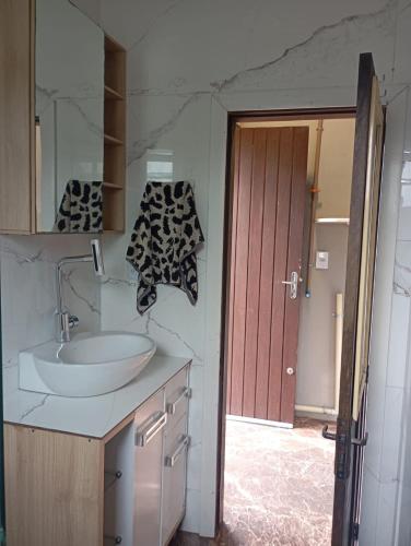 een badkamer met een wastafel, een spiegel en een deur bij net kit for 4 people in Torres