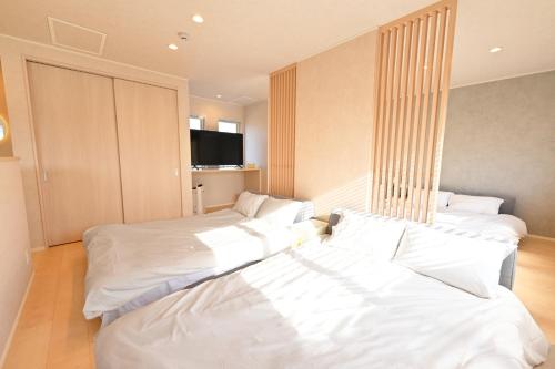 zwei Betten in einem Zimmer mit weißen Laken in der Unterkunft 8Room - Vacation STAY 70877v in Yachimata