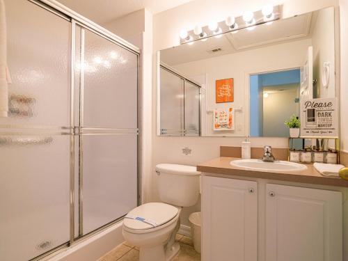 a bathroom with a shower and a toilet and a sink at The Enchanted luxe Townhome in Kissimmee