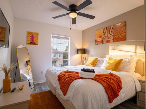 a bedroom with a large bed and a ceiling fan at The Enchanted luxe Townhome in Kissimmee