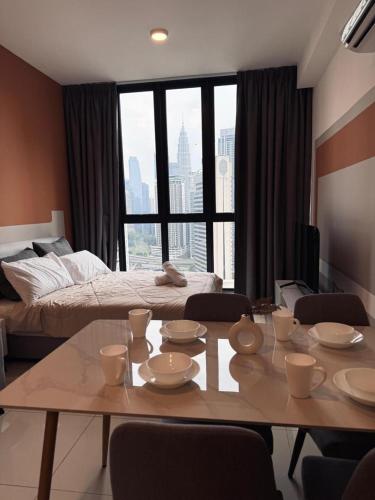 a living room with a table and a bed at Kampung Marsa at Majestic Residence, Kuala Lumpur in Kuala Lumpur